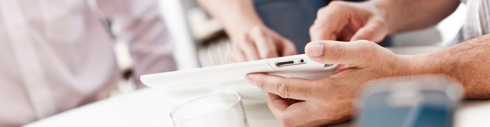 Mehrere Hände bei der Bedienung eines Tablets